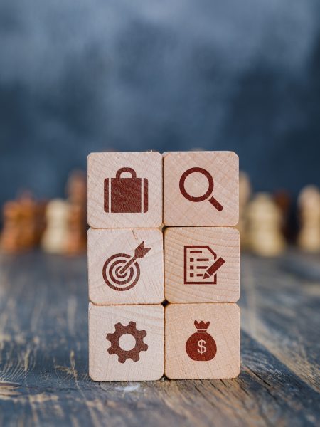 Business strategy concept with wooden cubes, chess figures on gloomy and wooden background side view.